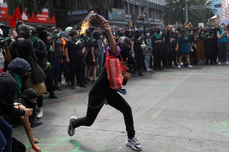 Member of a feminist collective throws a Molotov cocktail during a march to mark the International Safe Abortion Day in Mexico City. REUTERS/Carlos Jasso   